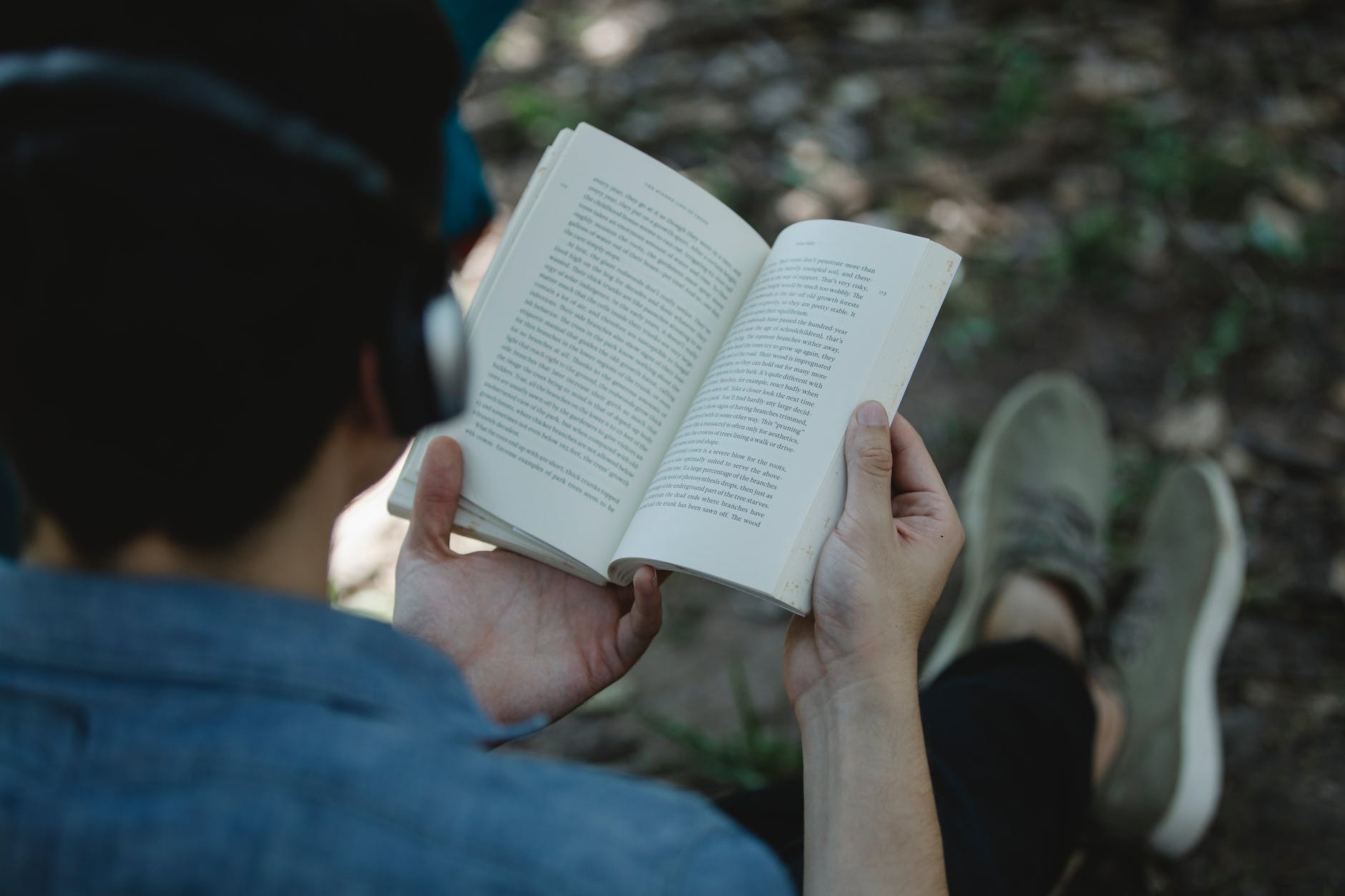 crop man in headphones reading book