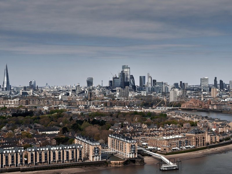 A breathtaking panoramic view of London’s skyline with the River Thames reflecting the city lights at sunset.