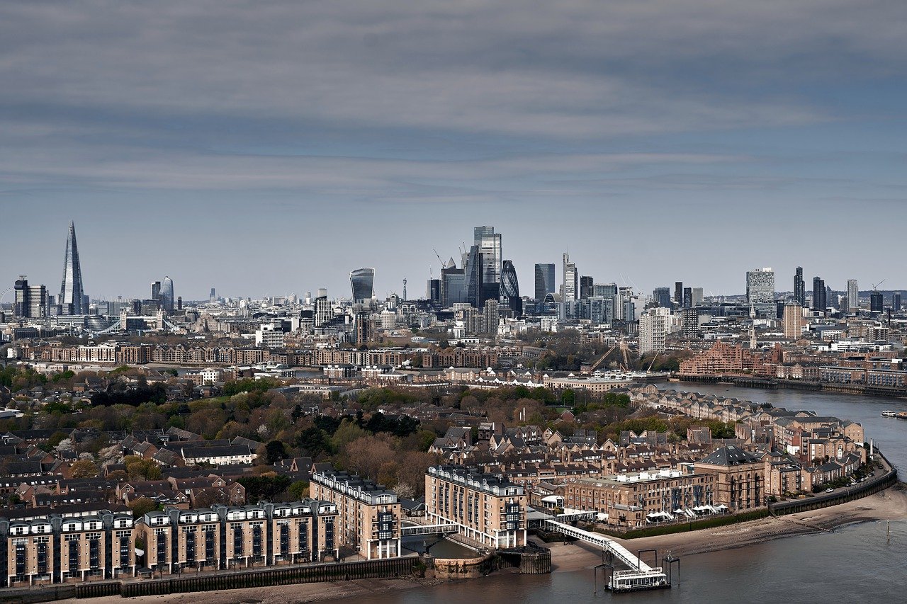 A breathtaking panoramic view of London’s skyline with the River Thames reflecting the city lights at sunset.