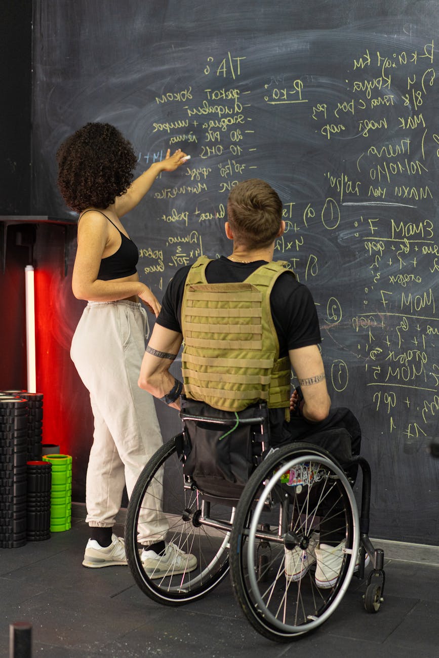 Turismo Inclusivo woman with man in wheelchair by blackboard
