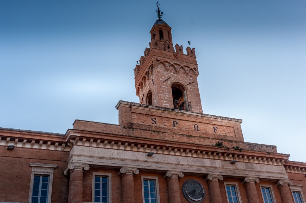 Vista della torre di un edificio storico a Foligno, Umbria, con il cielo blu sullo sfondo.