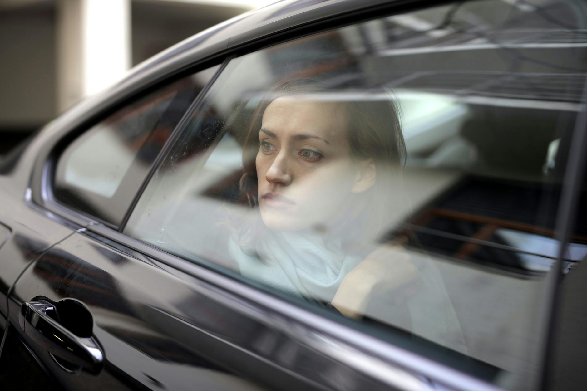 woman looking out while sitting inside the car