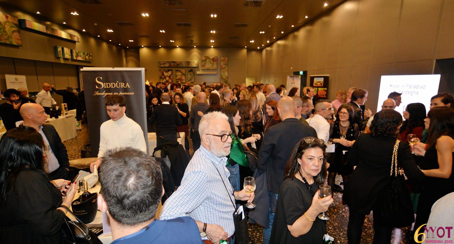 Un affollato evento Wine on Tour Sardegna presso il Thotel di Cagliari, con partecipanti che celebrano i vini premiati e socializzano tra stands.
