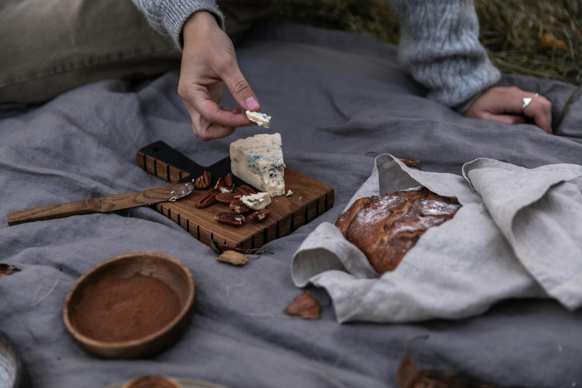 woman sitting on blanket and eating during picnic