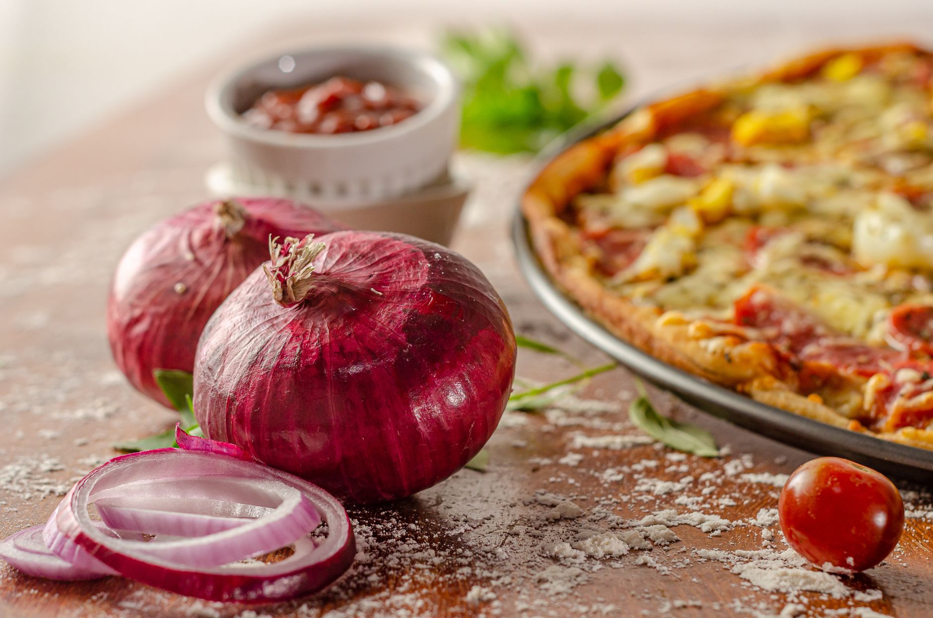 red onions on table near pizza