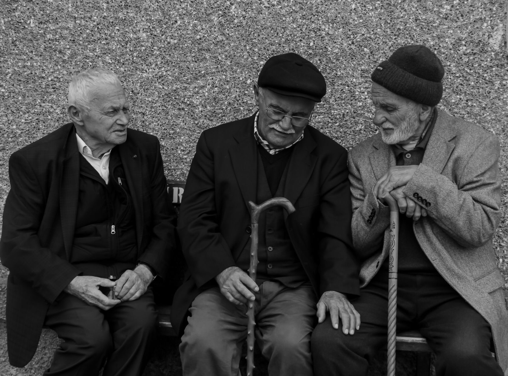 Foto in bianco e nero di un gruppo di anziani seduti a conversare
